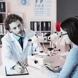 Optometrista consultando con paciente y tomando notas en SanAngel