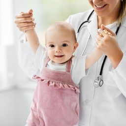 Pediatra sosteniendo a bebé sonriente en SanAngel